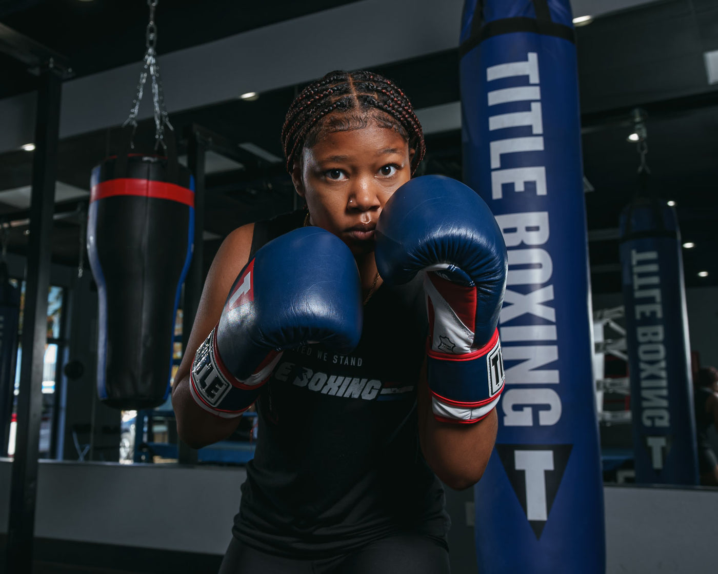 variant:navy/red::TITLE Boxing Gel World V2T Bag Gloves right jab to bag girl boxing stance