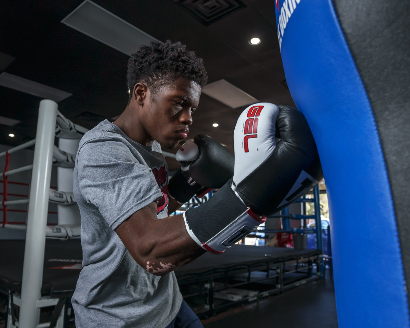 variant:Black::TITLE Boxing Gel World Elastic Training Gloves hitting blue bag