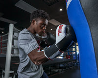 variant:Black::TITLE Boxing Gel World Elastic Training Gloves hitting blue bag