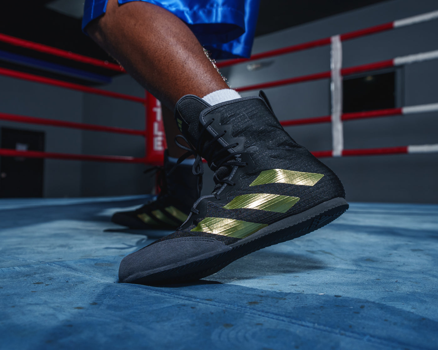 variant:black/gold::Adidas Box Hog 4 Boxing Boots feet on ring