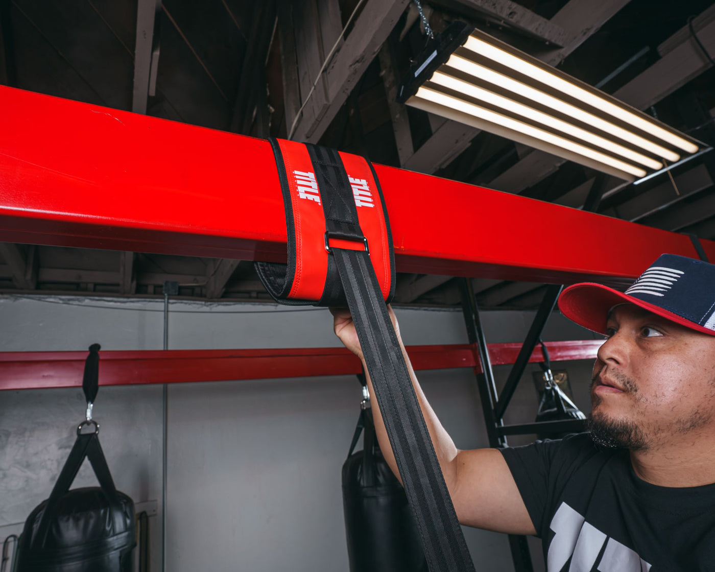 variant:lifestyle::TITLE Boxing Universal Heavy Bag Hanger being tightened by a boxer