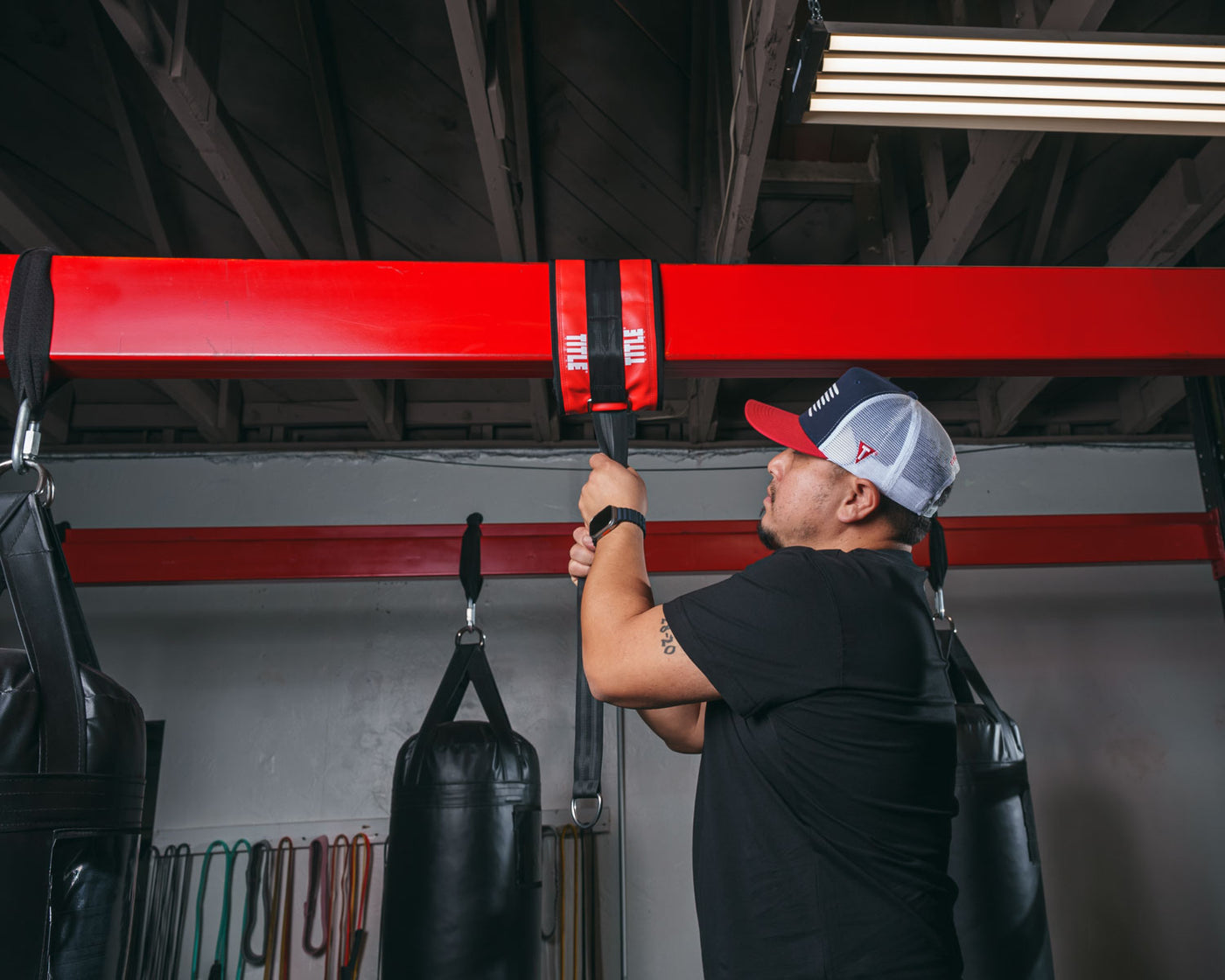 variant:lifestyle::TITLE Boxing Universal Heavy Bag Hanger being installed in a boxing gym