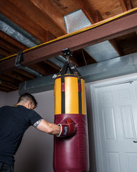 variant:lifestyle::TITLE Boxing I-Beam Heavy Bag Hanger holding a heavy bag