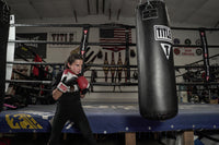 variant:lifestyle::TITLE Boxing Professional Choice 125lb Synthetic Leather Heavy Bag girl hitting bag