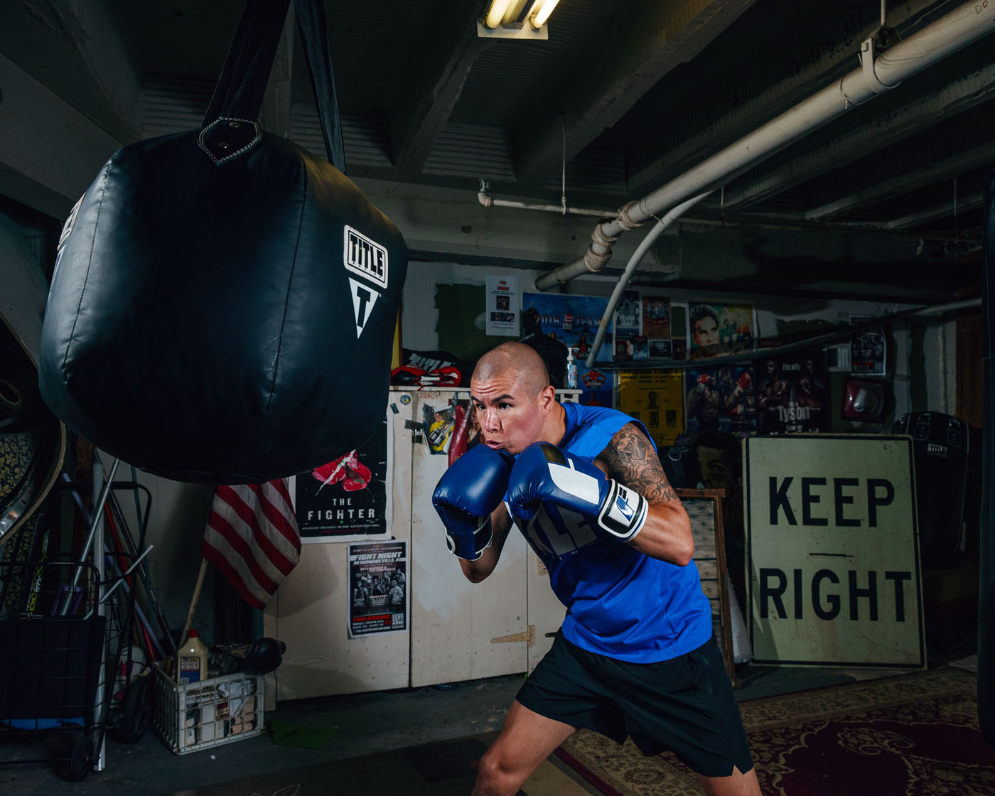 variant:lifestyle::TITLE Boxing Body Snatcher Bag guy shadow boxing with bag
