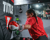 variant:lifestyle::TITLE Boxing Infused Foam EI Combat Mexico Training Gloves girl hitting the bag left jab