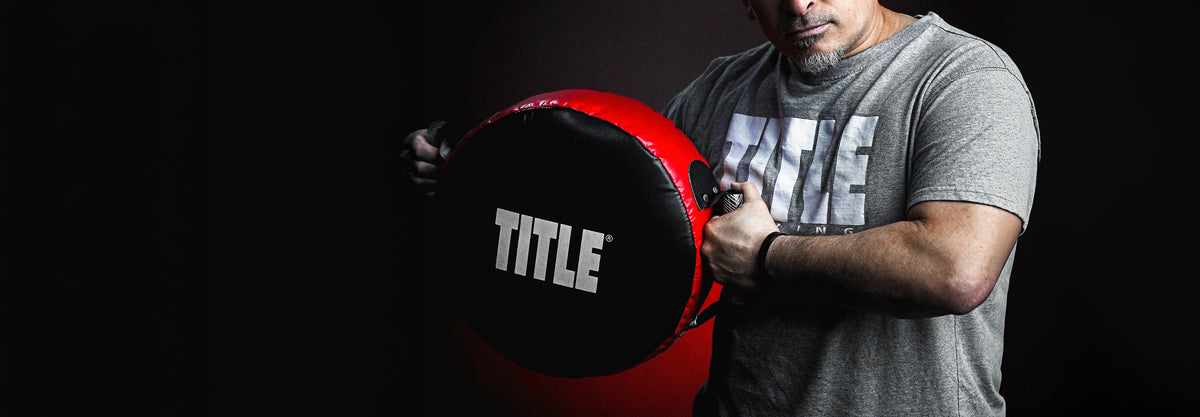 boxing coach holding a punch shield