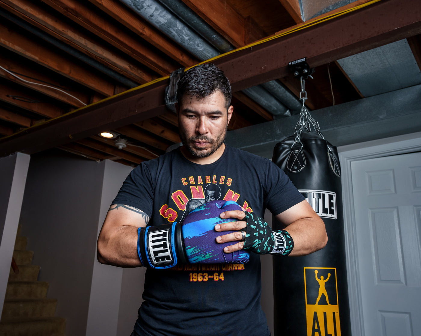 variant:lifestyle::TITLE Boxing Infused Electric Bag Gloves Rudy one hand in glove other wrapped
