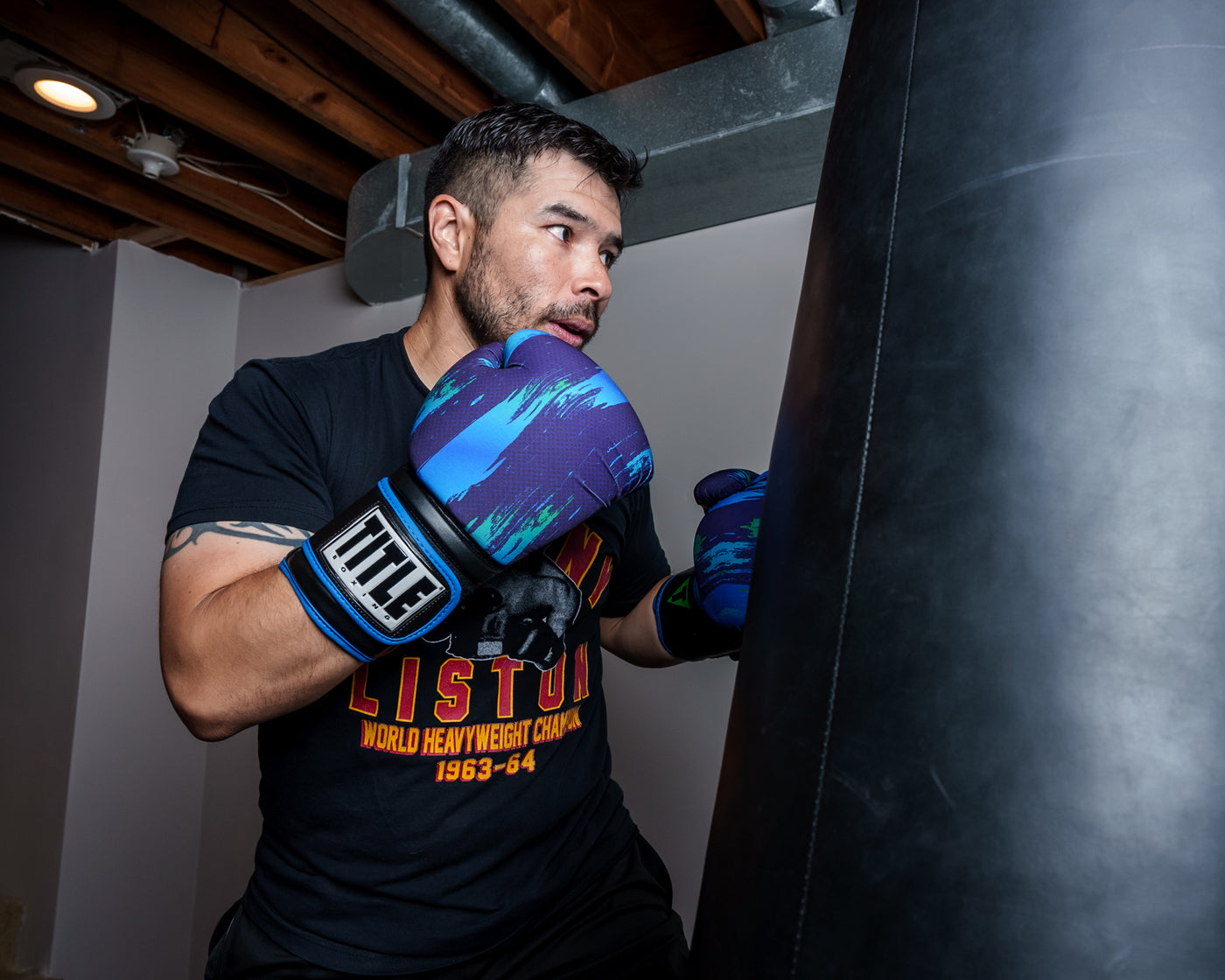 variant:lifestyle::TITLE Boxing Infused Electric Bag Gloves Rudy boxing stance with bag