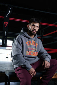 variant:Dark Grey::TITLE Boxing Legacy KRONK Training Camp Hoodie guy sitting by ring