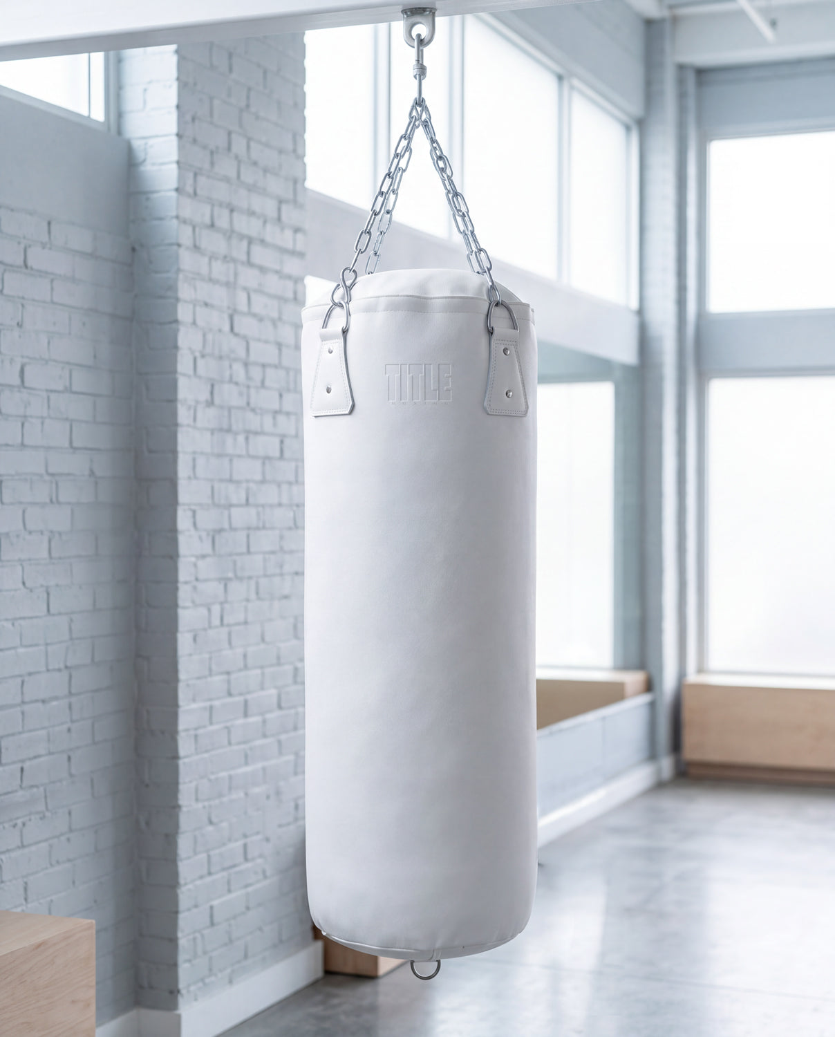 variant:white::TITLE Boxing KO-Vert Heavy Bag hanging in the gym