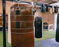 variant:brown::TITLE Boxing KO-Vert Leather Heavy Bag closeup of bag hanging in the gym
