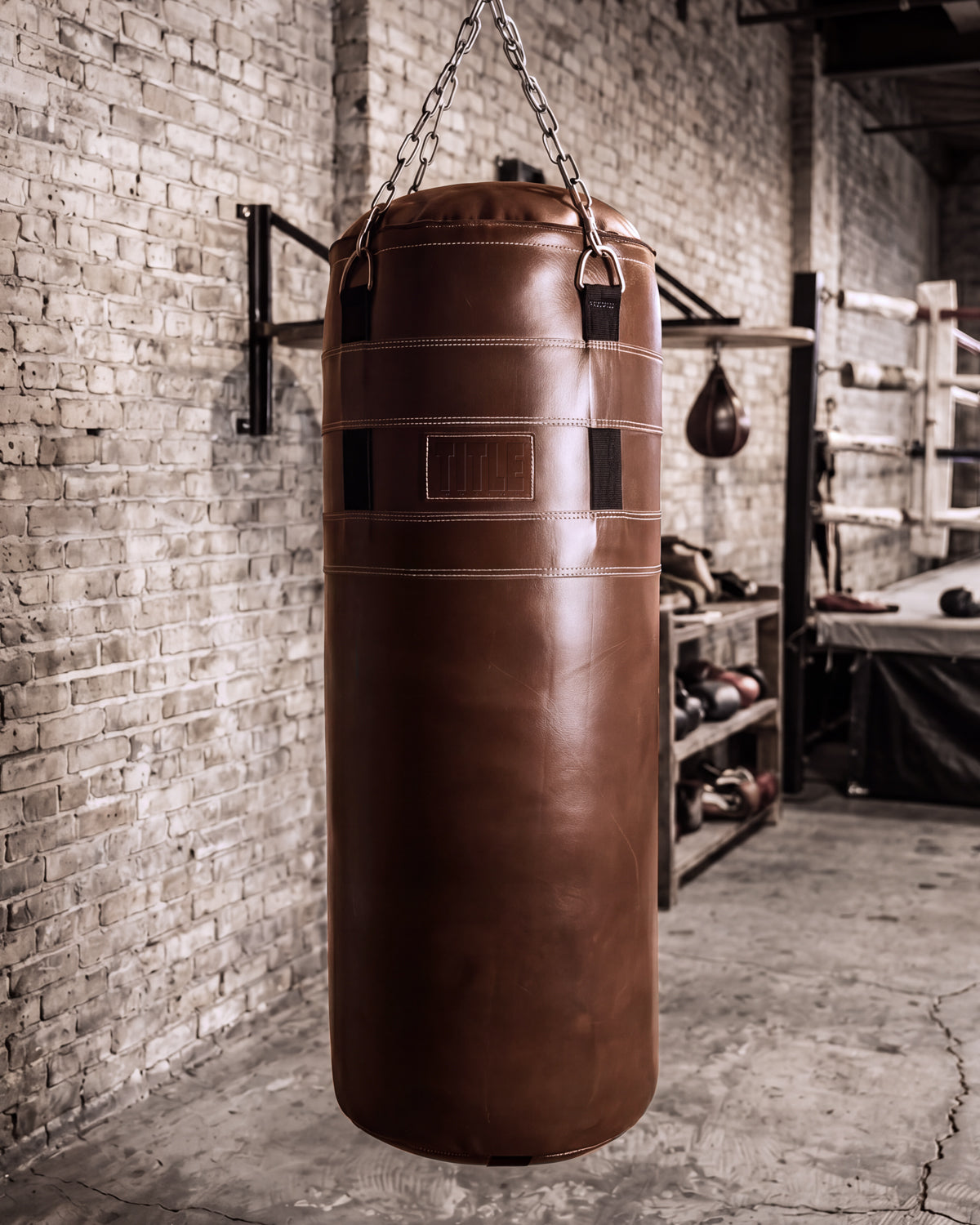 variant:brown::TITLE Boxing KO-Vert Leather Heavy Bag hanging in the gym