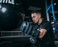 variant:black/grey::TITLE Boxing Liberty Bag Gloves guy hitting bag