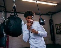 variant:white::TITLE Boxing Thermal Wear Long Sleeve guy infront of small bag