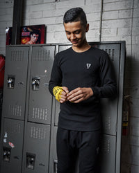 variant:black::TITLE Boxing Thermal Wear Long Sleeve man in front of lockers