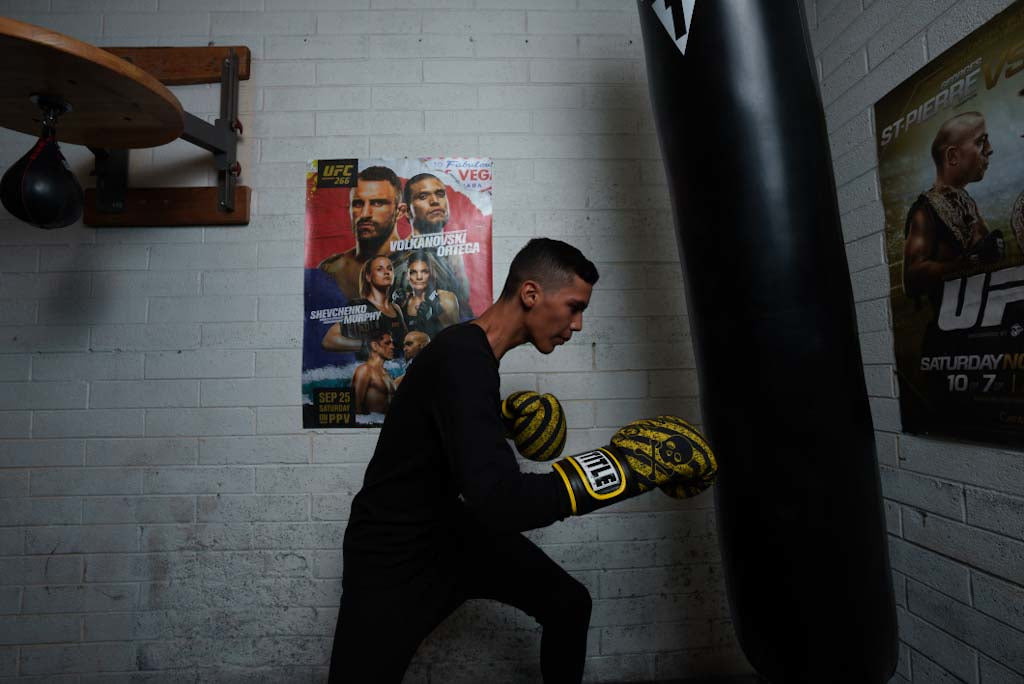 variant:black::TITLE Boxing Thermal Wear Pants kid hitting bag