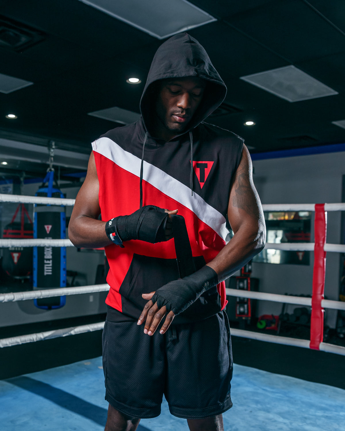 variant:black/red::TITLE Boxing Split Sleeveless Hoodie guyputting on wraps