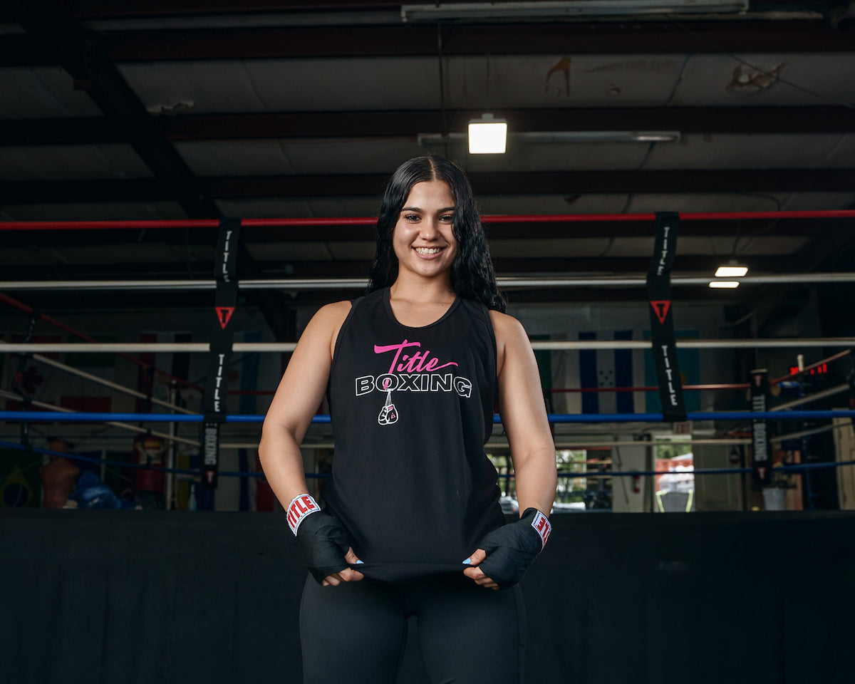 variant:black::TITLE Boxing Chic Script Women's Tank girl showing tank infront of ring