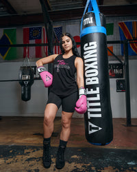 variant:black::TITLE Boxing Chic Script Women's Tank girl showing tank infront of bag