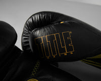 variant:black/gold::TITLE Boxing Momentum Pro Bag Gloves closeup of logo on thumb