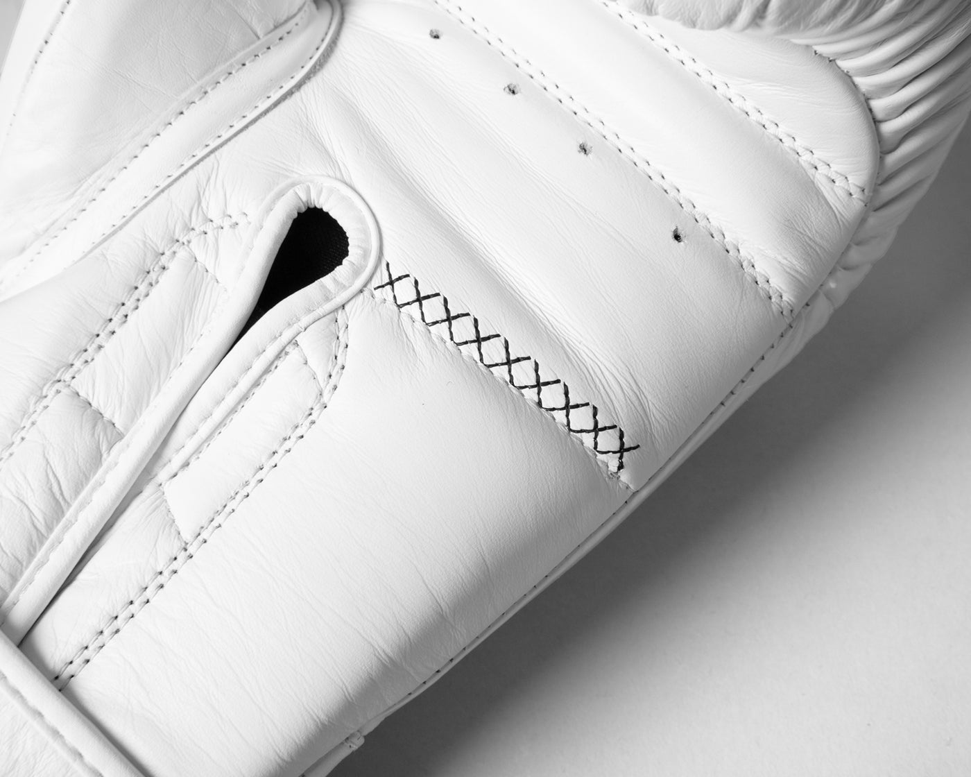 variant:white::TITLE Boxing Momentum Pro Bag Gloves closeup of stitching