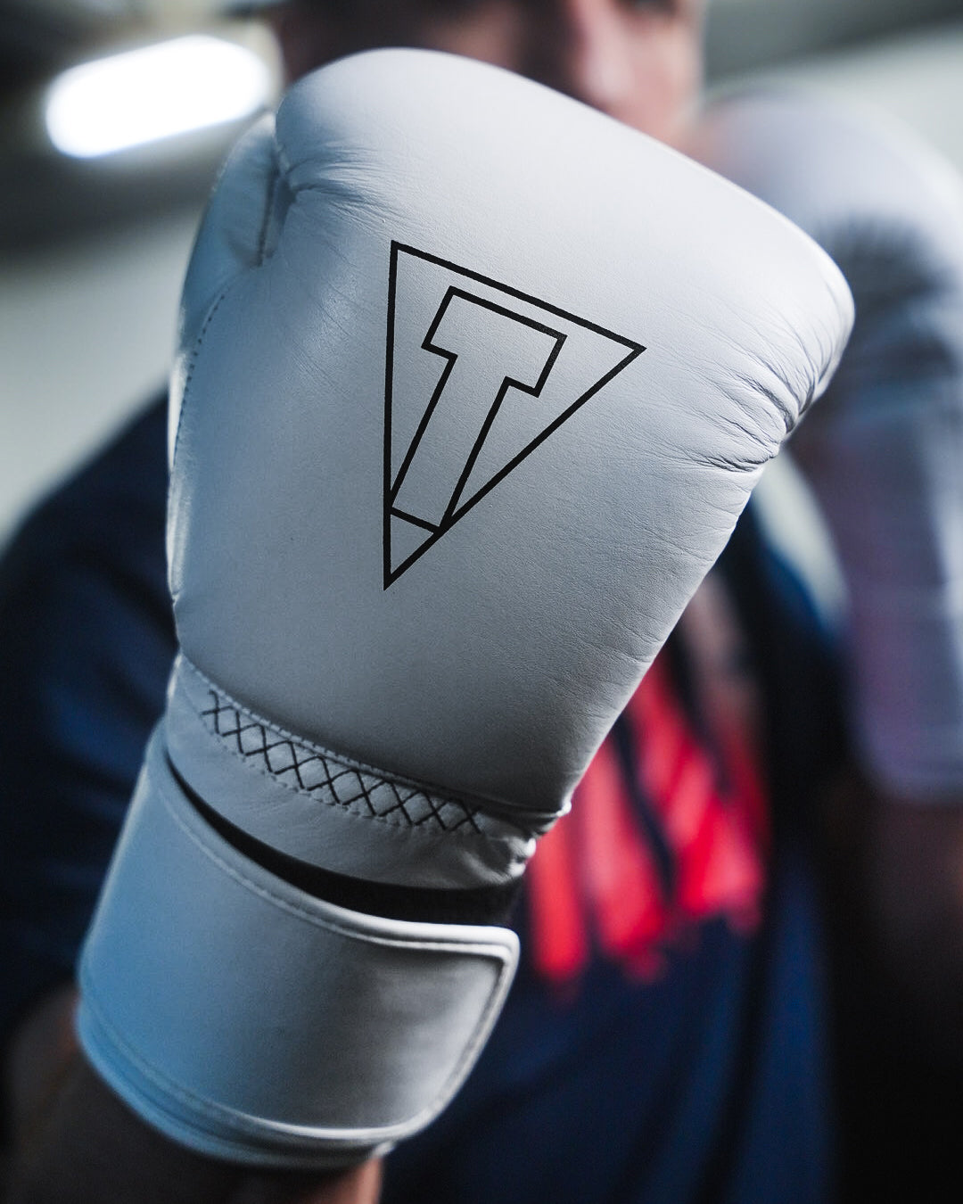 variant:white::TITLE Boxing Momentum Pro Bag Gloves closeup on boxer's hand