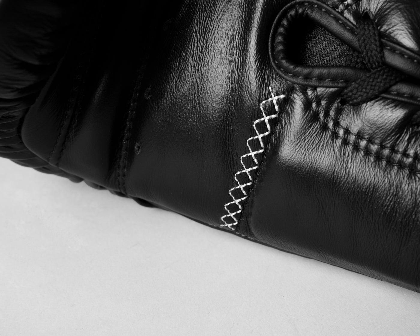 variant:black::TITLE Boxing Momentum Pro Sparring Gloves closeup of stitching