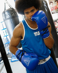 variant:blue/silver::TITLE Boxing Momentum Pro Sparring Gloves on boxer's hands fighting stance