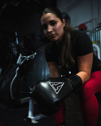 variant:black::TITLE Boxing Momentum Pro Training Gloves on boxer at the gym