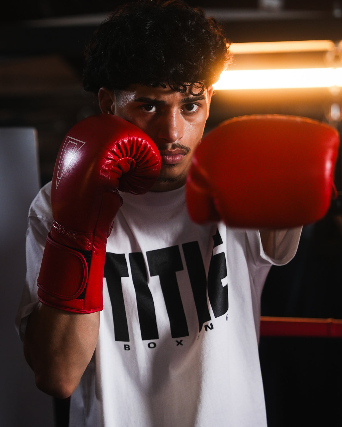 variant:red::TITLE Boxing Momentum Pro Training Gloves on boxer's hands fighting stance