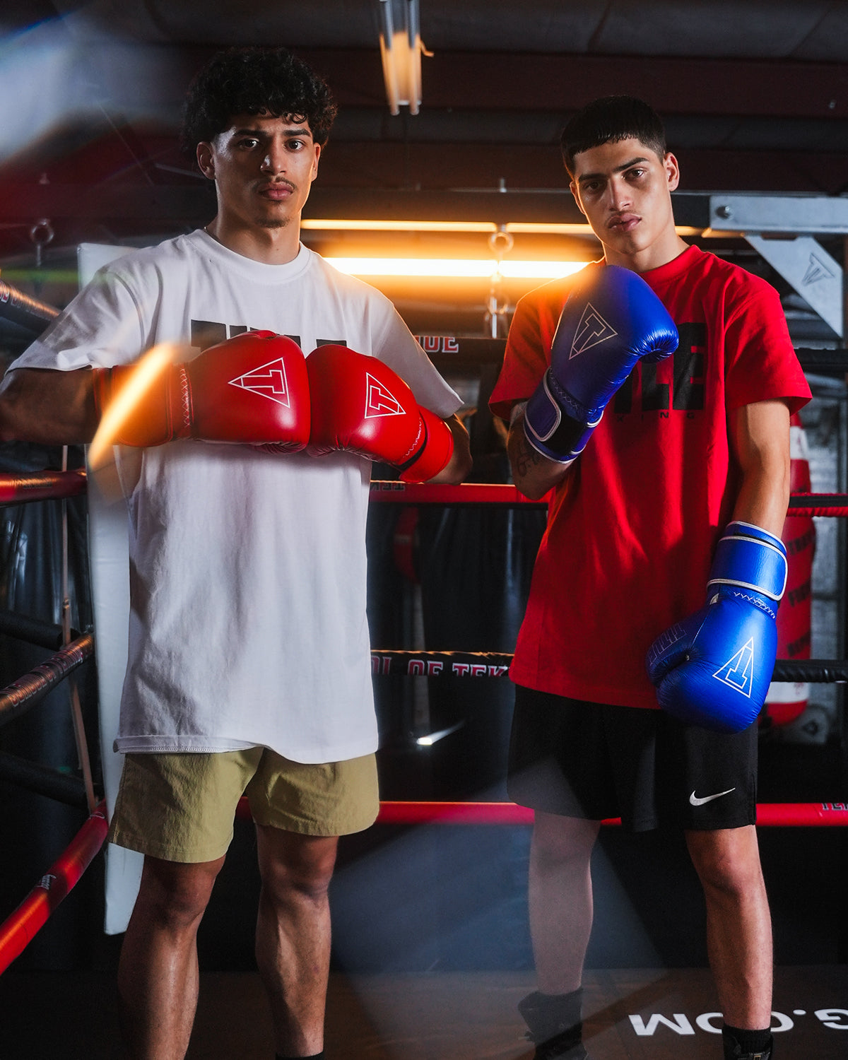 variant:red::TITLE Boxing Momentum Pro Training Gloves on boxers hands next to other boxer in ring