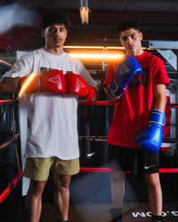 variant:red::TITLE Boxing Momentum Pro Training Gloves on boxers hands next to other boxer in ring