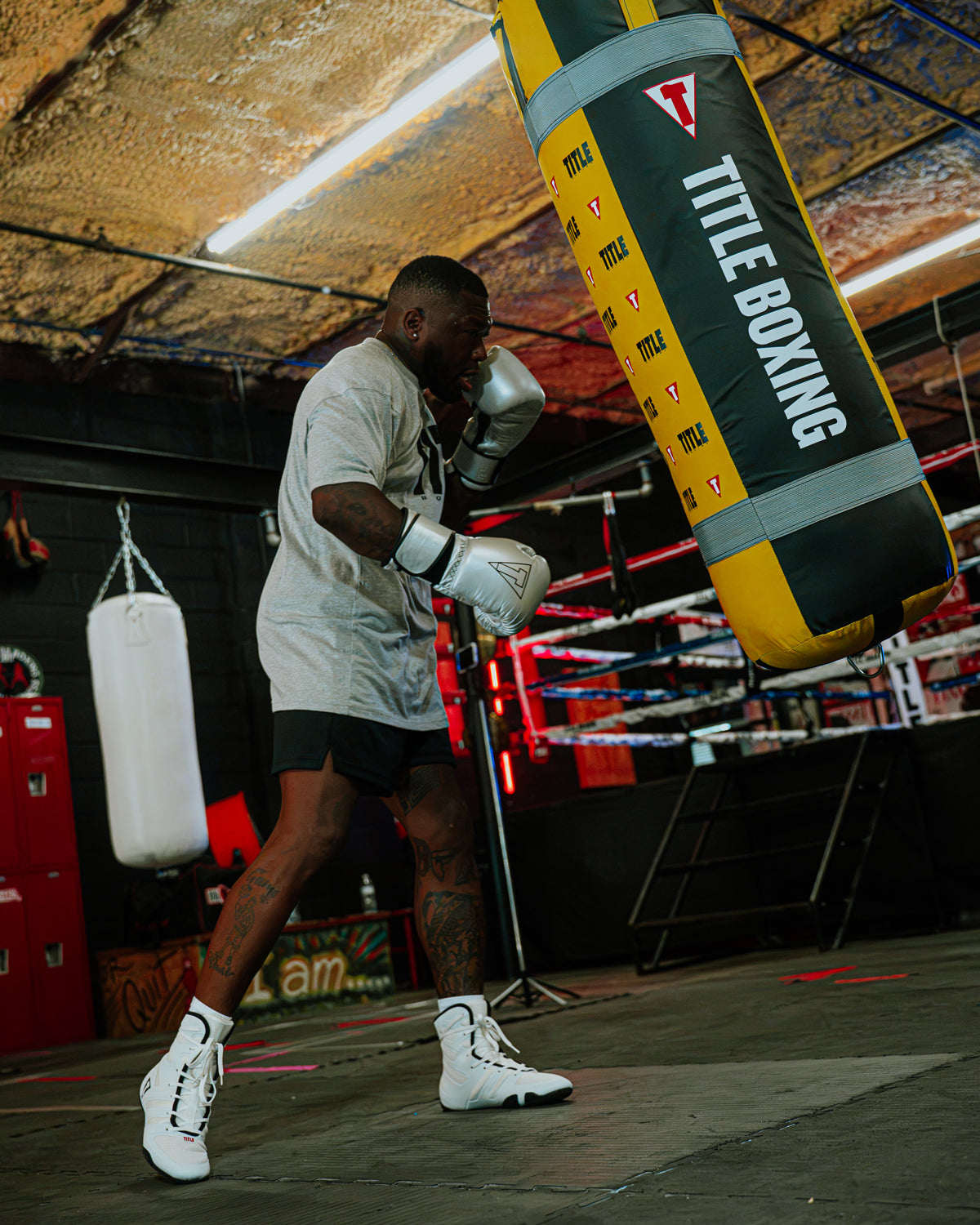 variant:Silver/Black::TITLE Boxing Momentum Pro Training Gloves boxer hitting heavy bag in the gym with gloves on