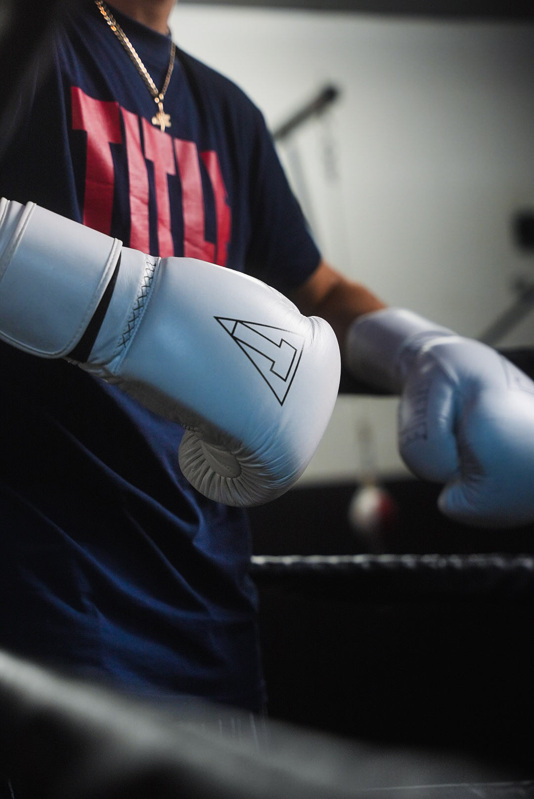 variant:white::TITLE Boxing Momentum Pro Training Gloves closeup of glove on boxer's hands in the ring