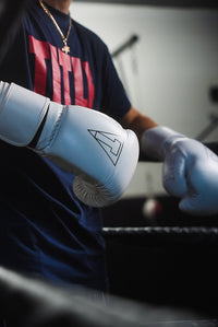 variant:white::TITLE Boxing Momentum Pro Training Gloves closeup of glove on boxer's hands in the ring