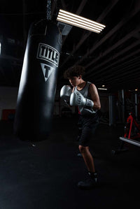 variant:lifestyle::TITLE Boxing Professional Choice 125lb Synthetic Leather Heavy Bag guy hitting bag silver promex gloves