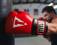 variant:red/black::TITLE Boxing Oversize SAFE-T Contact Gloves boxer hitting bag with closeup of glove