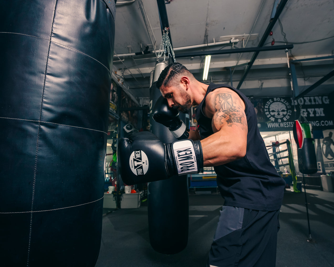 variant:Black::Pro Mex Professional Bag Gloves V3.0 guy hitting heavy bag