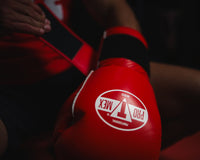 variant:red::Pro Mex Professional Edge Training Gloves being put on by boxer