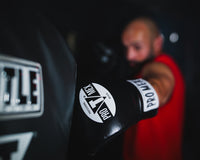 variant:Black::Pro Mex Professional Heavy Bag Gloves on boxer hitting bag
