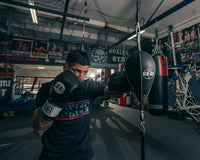 variant:7" x 11"::Pro Mex Professional Double End Bag V2.0 guy hitting the bag with a jab