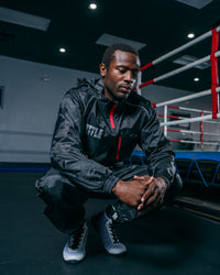 variant:lifestyle::TITLE Platinum Prevail Rubberized Sauna Suit squatting  pose