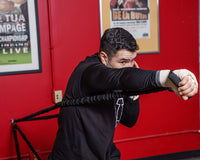 variant:lifestyle::TITLE Boxing Powerquad Resistance System boxer punching using the resistance band
