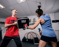 variant:Lifestyle::TITLE Boxing Square Punch and Kick Shield coach with lady