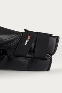 variant:Black::Close-up of a black martial arts pad with a black elastic strap featuring the WestJet2 logo in white and orange, set against a light gray background.