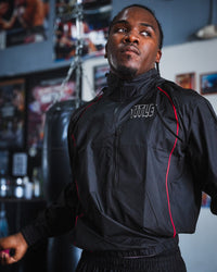 variant:lifestyle::TITLE Boxing Reign Rubberized Sauna Suit on boxer jumping rope in the gym