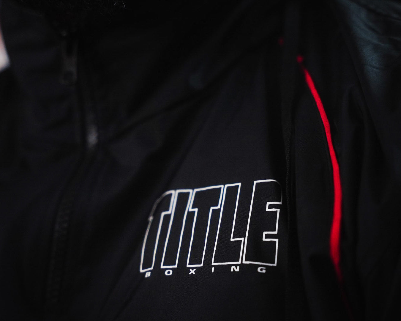variant:lifestyle::TITLE Boxing Reign Rubberized Sauna Suit closeup of logo on top