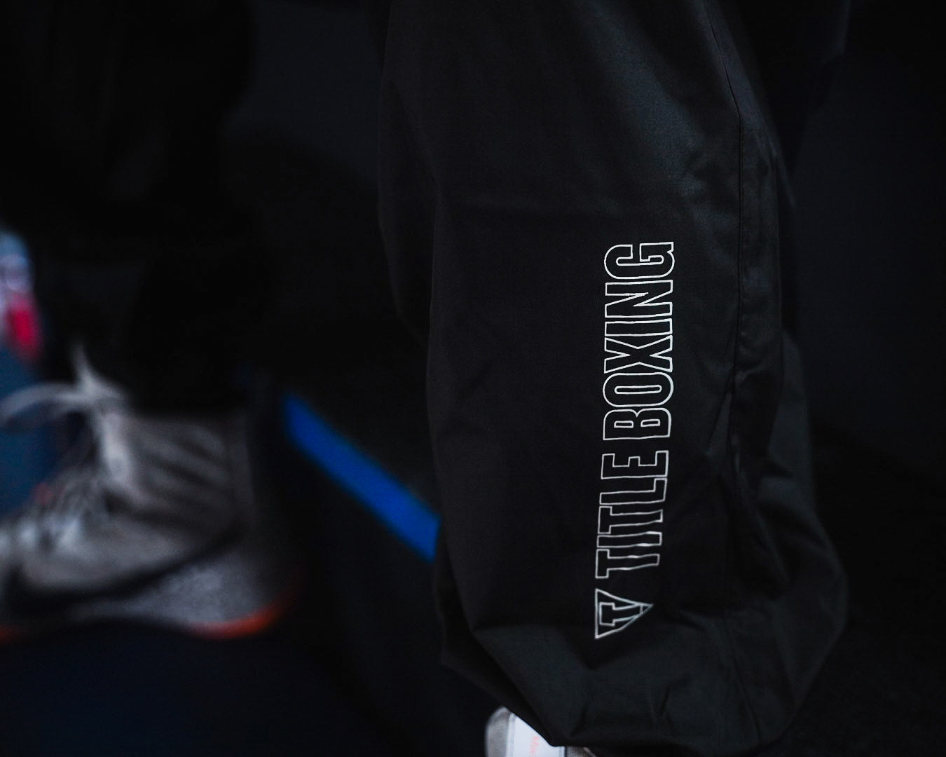 variant:lifestyle::TITLE Boxing Reign Rubberized Sauna Suit closeup of logo on bottom