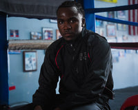 variant:lifestyle::TITLE Boxing Reign Rubberized Sauna Suit on boxer sitting ringside